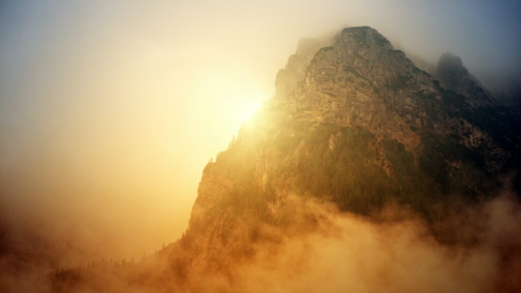 Mountain with the sun slightly behind it