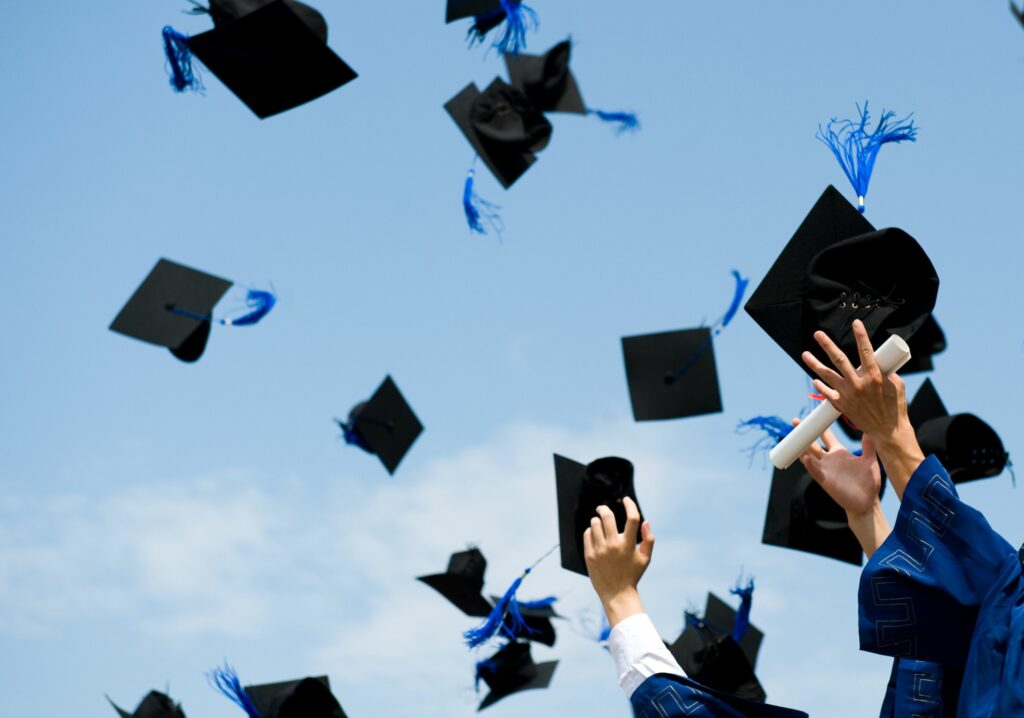 Students throwing their gown cap in the air